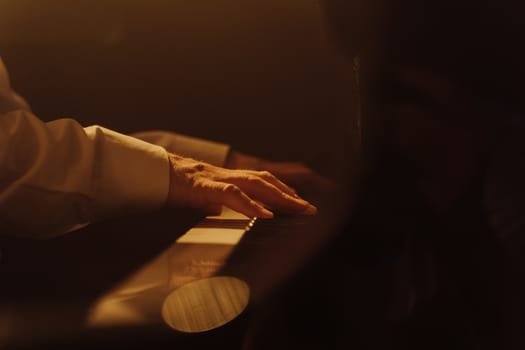 A close-up view of a hand playing a piano in warm lighting, capturing musical emotion.